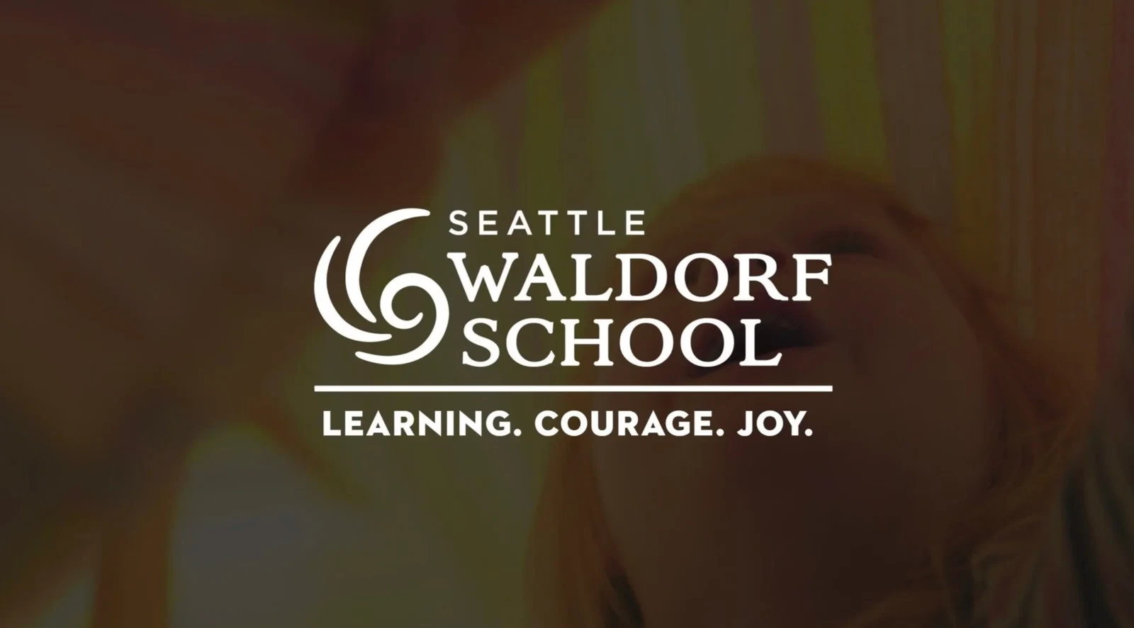 Seattle Waldorf School title card, reading Learning. Courage. Joy., over a softly focused image of a child